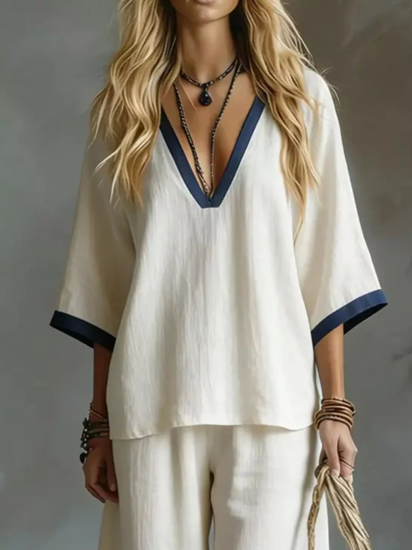 NEWYORKLISTED STYLE COLLECTION: Woman wearing a white outfit with blue trim against a neutral background