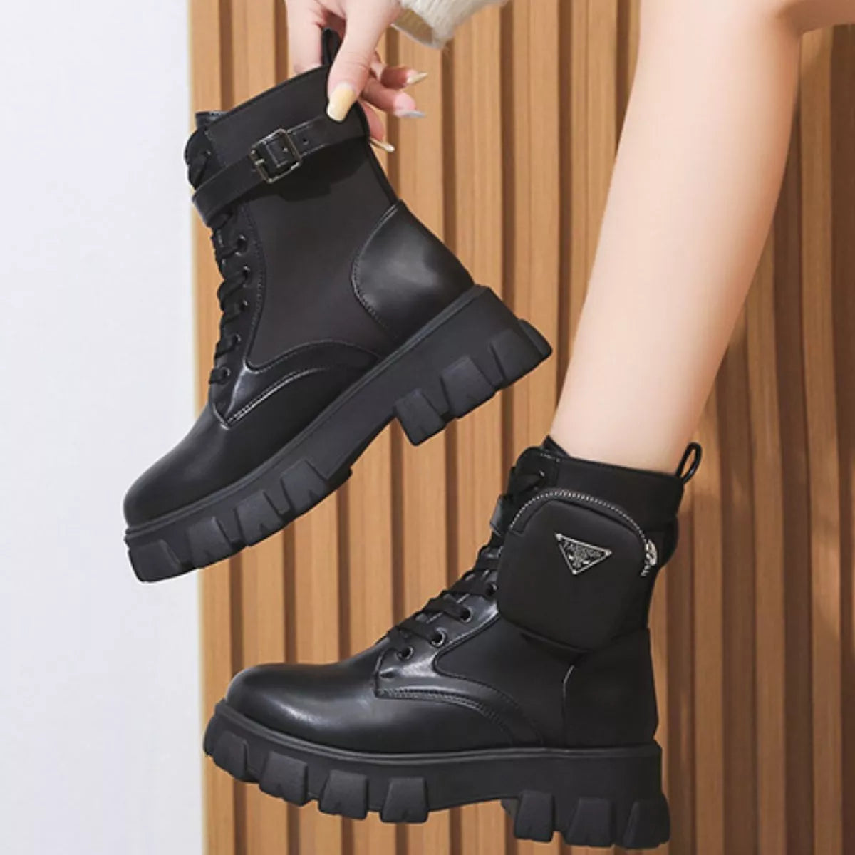 NEWYORKLISTED SHOE COLLECTION: Black boots being held up against a neutral background