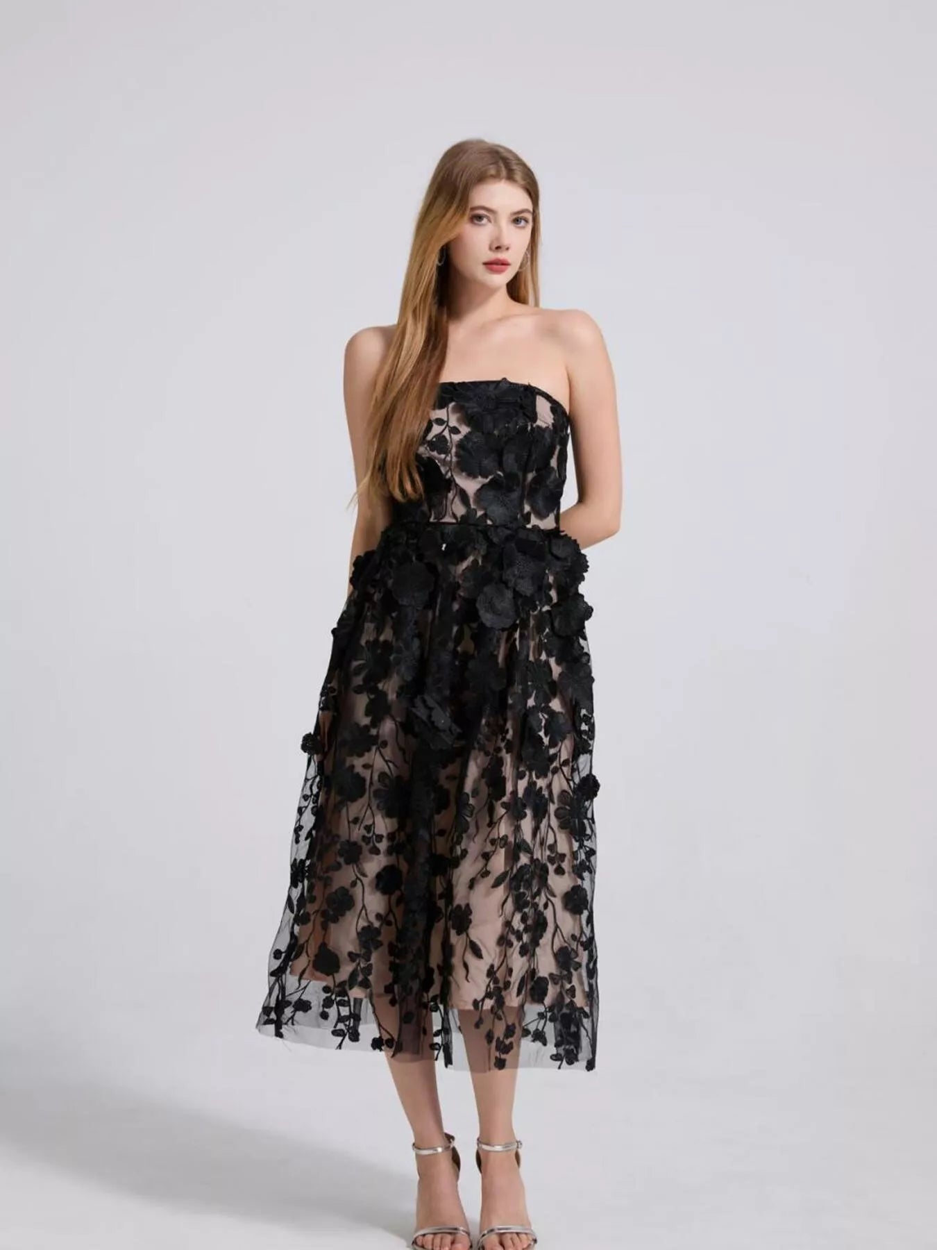 NEWYORKLISTED STYLE COLLECTION: Woman wearing a black floral strapless dress on a white background