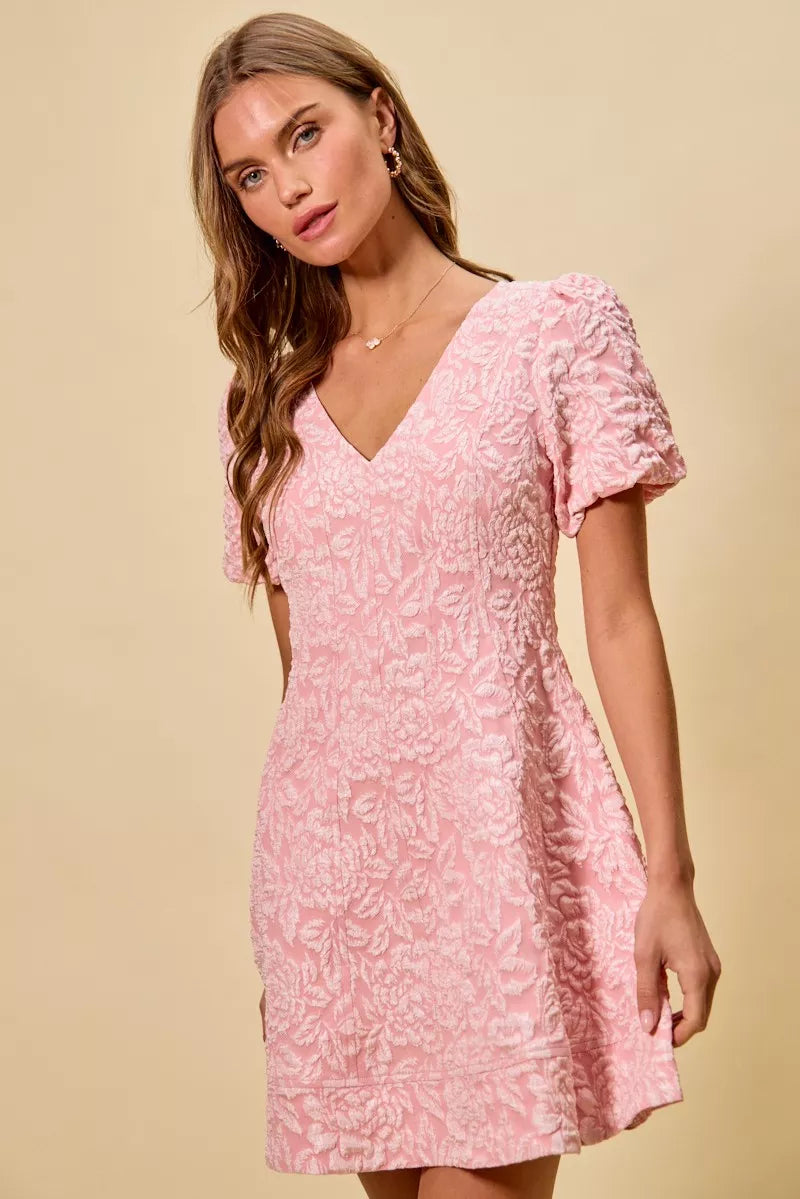NEWYORKLISTED STYLE COLLECTION: Woman wearing a pink floral dress against a beige background