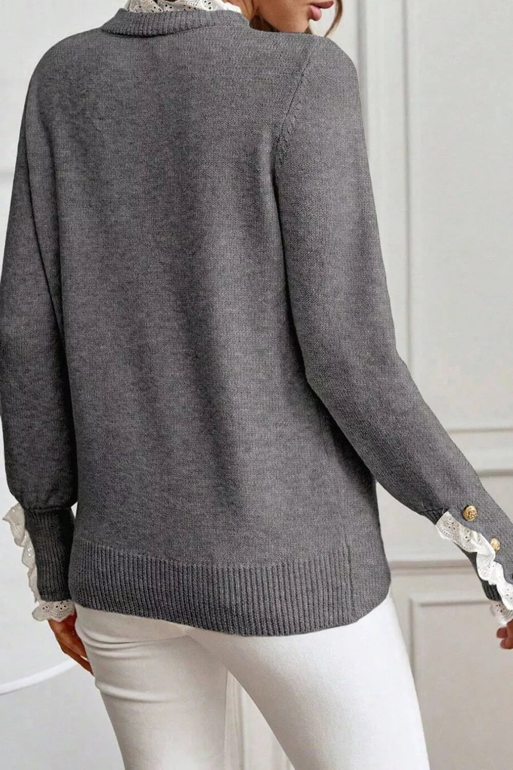 NEWYORKLISTED STYLE COLLECTION: Gray sweater with lace trim on sleeves and hem worn by a person.