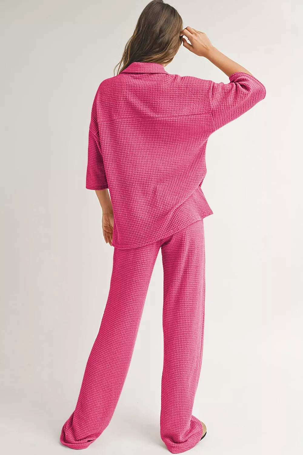 NEWYORKLISTED Comfort Collection: Person wearing a pink checkered pajama set on a plain background