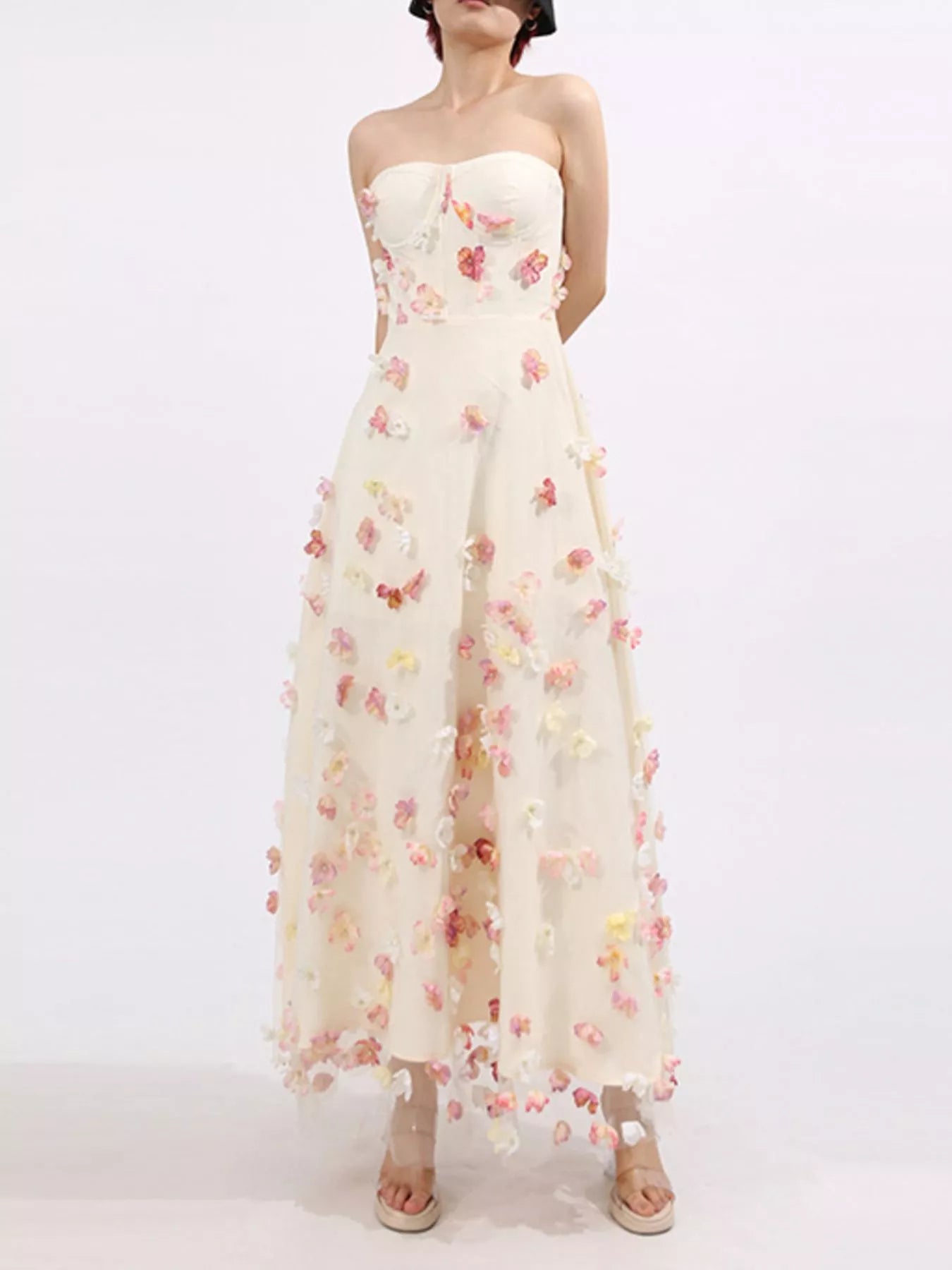 NEWYORKLISTED STYLE COLLECTION: Woman wearing a strapless floral dress on a white background