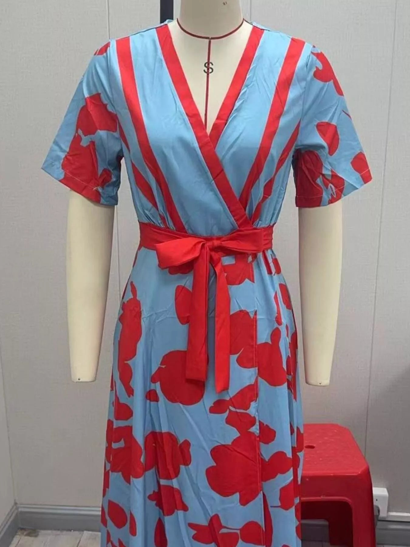 NEWYORKLISTED STYLE COLLECTION: Red and blue patterned dress on a mannequin against a plain background