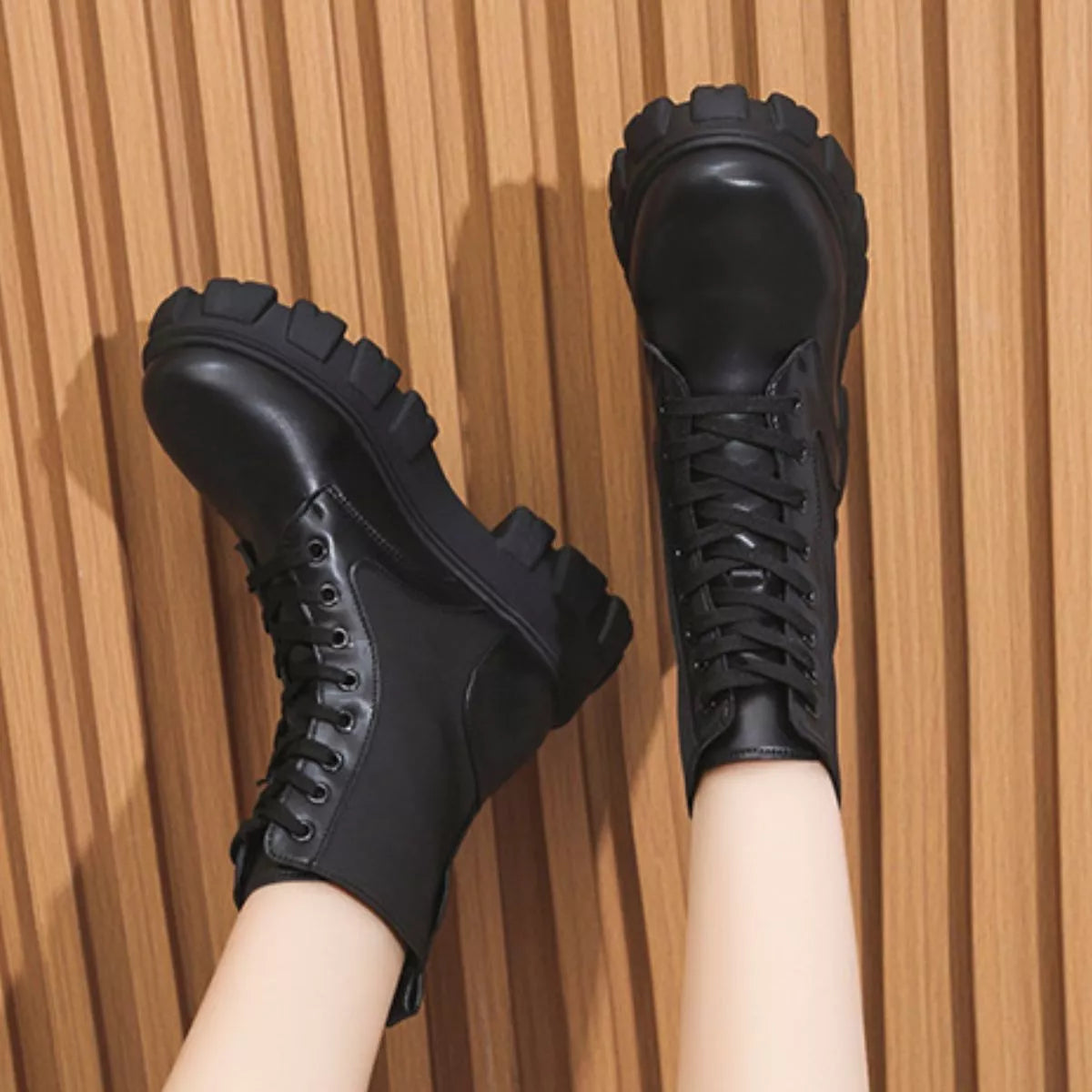 NEWYORKLISTED SHOE COLLECTION: Black lace-up boots on a wooden floor