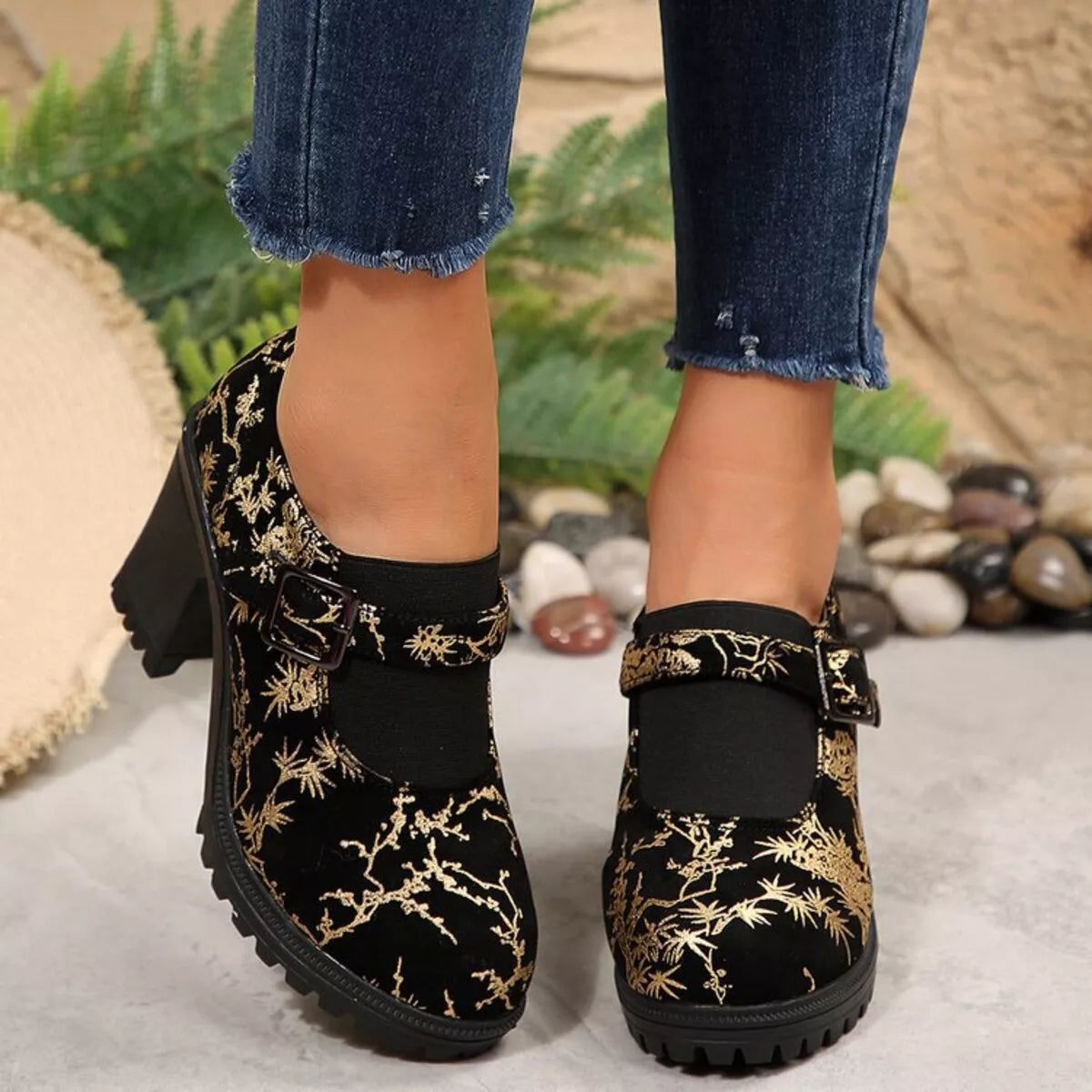 NEWYORKLISTED STYLE COLLECTION: Black floral embroidered boots worn with rolled-up jeans on a neutral background