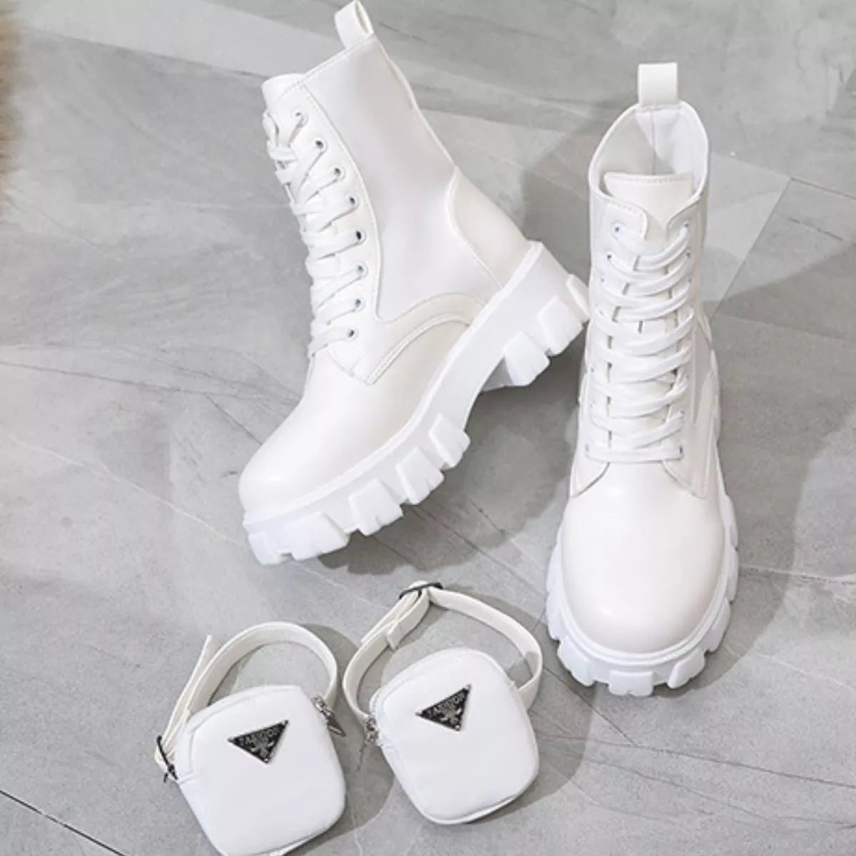 NEWYORKLISTED SHOE COLLECTION: White boots and matching pouches on a light wooden floor