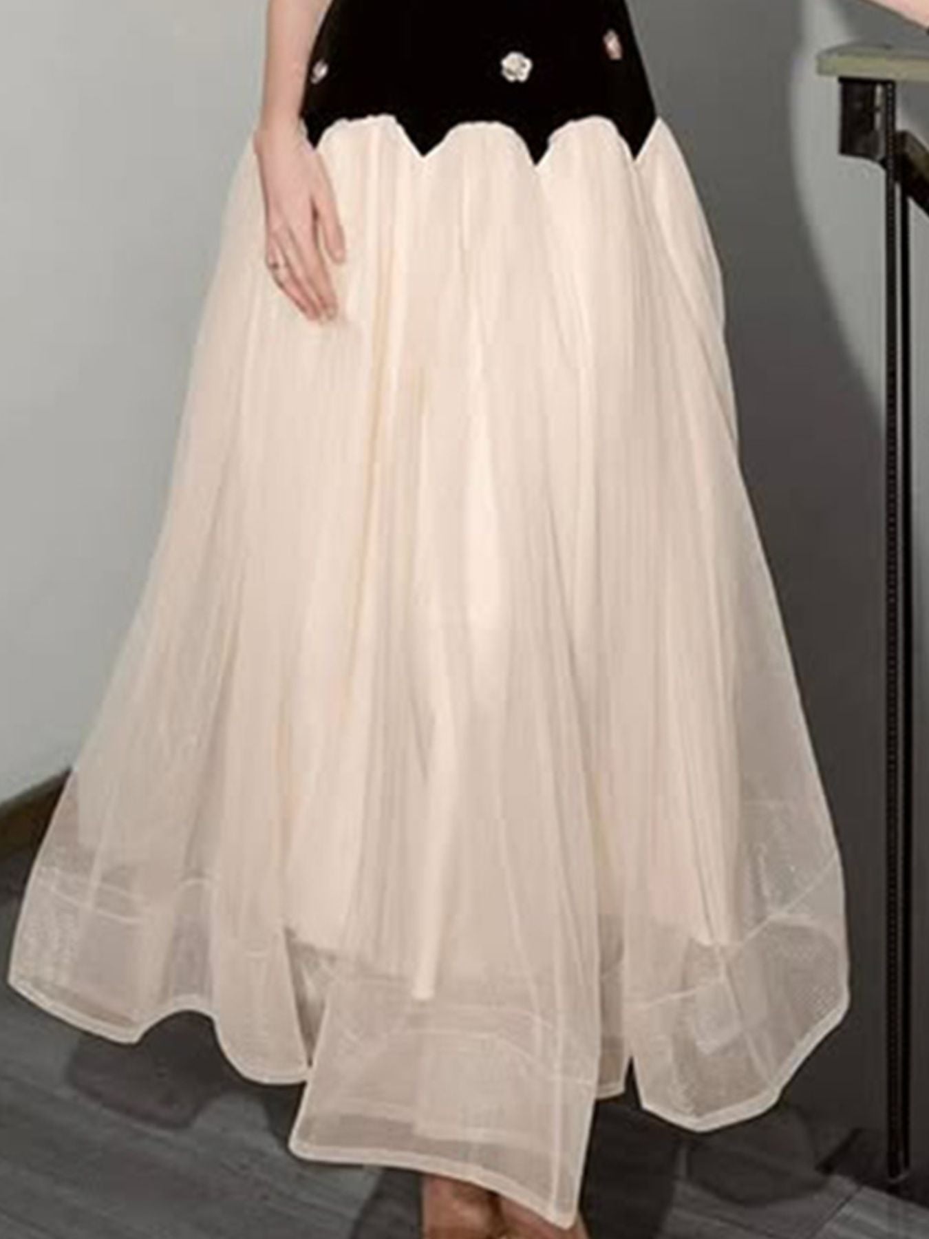 NEWYORKLISTED STYLE COLLECTION: Beige tulle skirt worn over a black top against a gray background