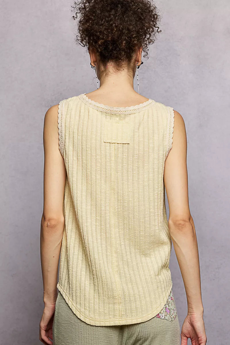 NEWYORKLISTED STYLE COLLECTION: Woman wearing a light yellow sleeveless top against a gray background