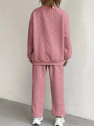 NEWYORKLISTED COMFORT COLLECTION: Person wearing a pink textured tracksuit against a plain background