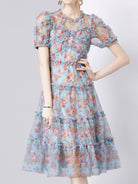 NEWYORKLISTED STYLE COLLECTION: Woman wearing a floral dress on a plain background