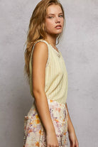 NEWYORKLISTED STYLE COLLECTION: Woman wearing a light-colored sleeveless top with a floral skirt against a gray background