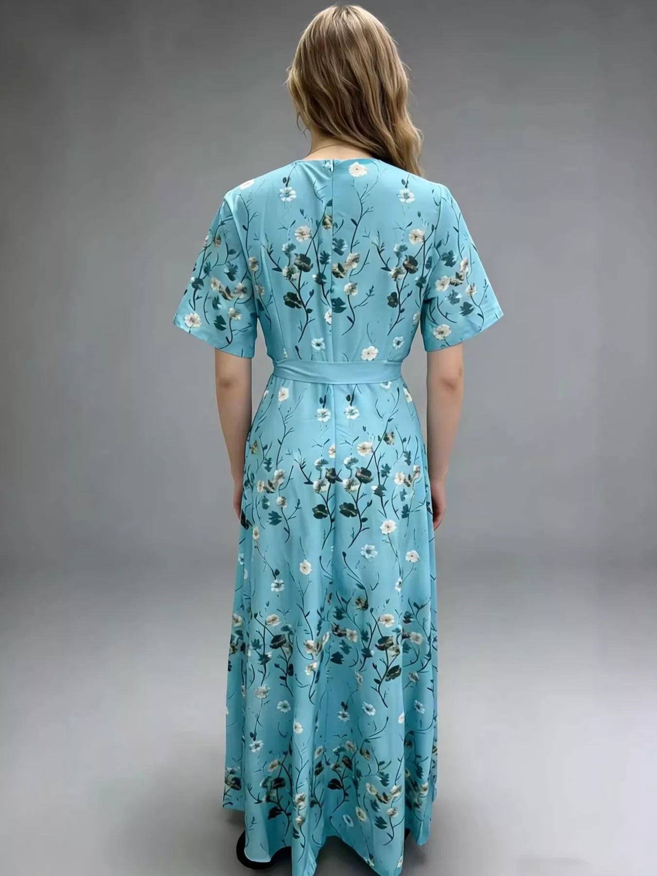 NEWYORKLISTED STYLE COLLECTION: Woman wearing a blue floral dress against a gray background