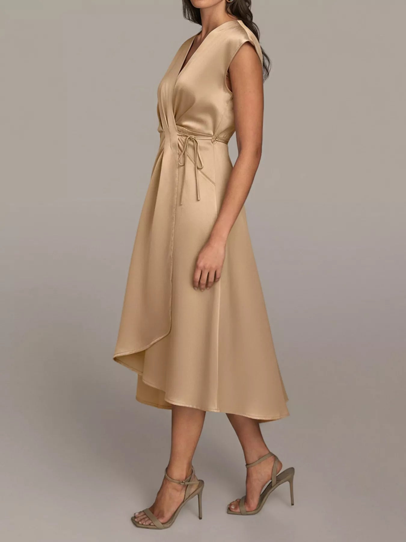 NEWYORKLISTED RUNWAY STYLE: Woman wearing a gold dress against a plain background