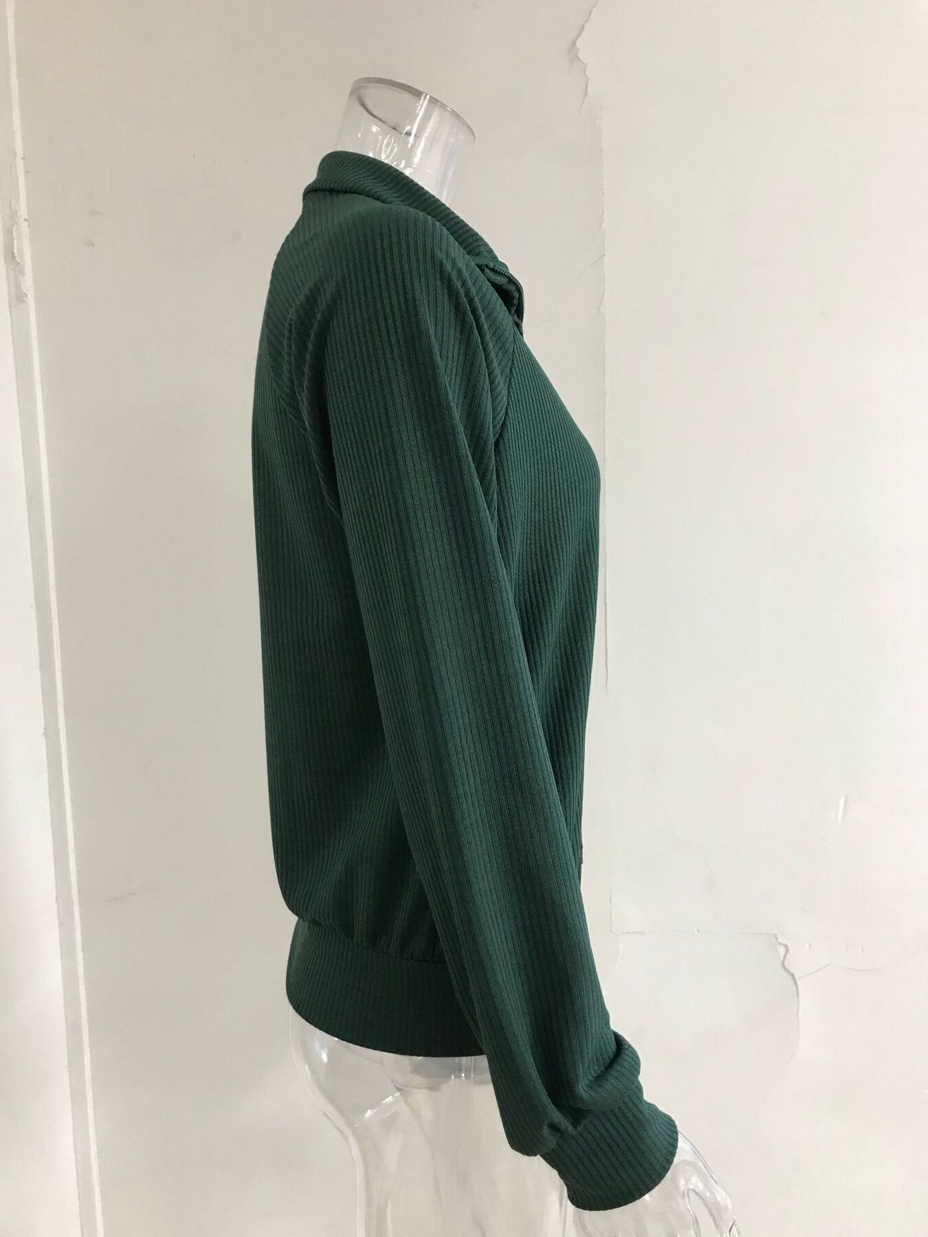 NEWYORKLISTED STYLE COLLECTION: Green ribbed sweater on a mannequin against a white background