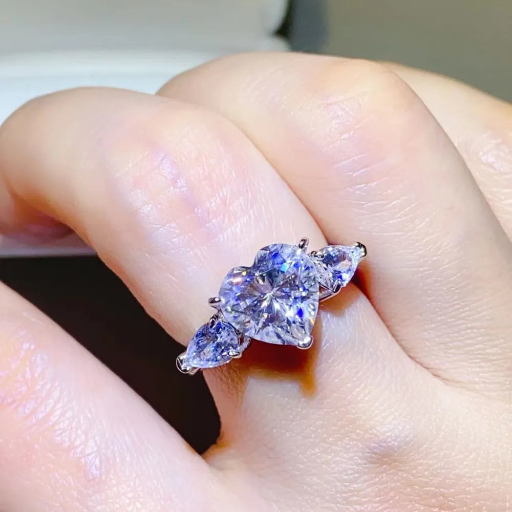 NYLD Glamour Collection By NEWYORKLISTED: Close-up of a hand wearing a silver ring with a large purple gemstone.