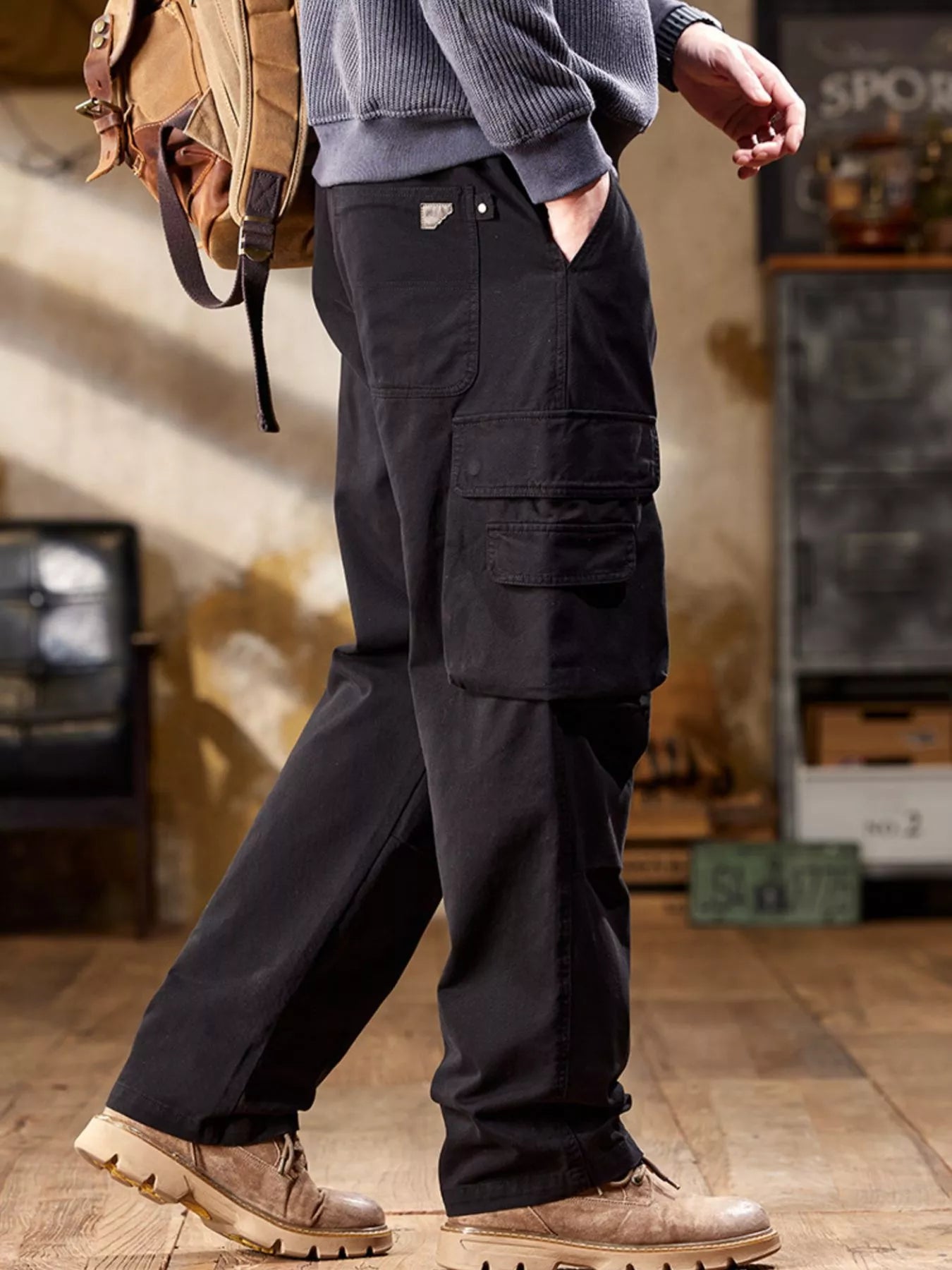 NEWYORKLISTED ATLAS MEN's COLLECTION: Person wearing dark cargo pants with a backpack indoors