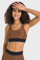 NEWYORKLISTED ACTIVEWEAR COLLECTION: Woman wearing a brown sports bra and leggings on a white background
