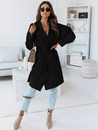 NEWYORKLISTED STYLE COLLECTION: Woman wearing a black coat in a modern living room