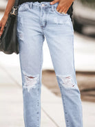 NEWYORKLISTED STYLE COLLECTION: Light blue ripped jeans worn by a person with a blurred background