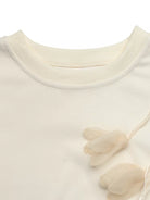 NEWYORKLISTED STYLE COLLECTION: Close-up of a cream-colored sweater with floral details on a white background