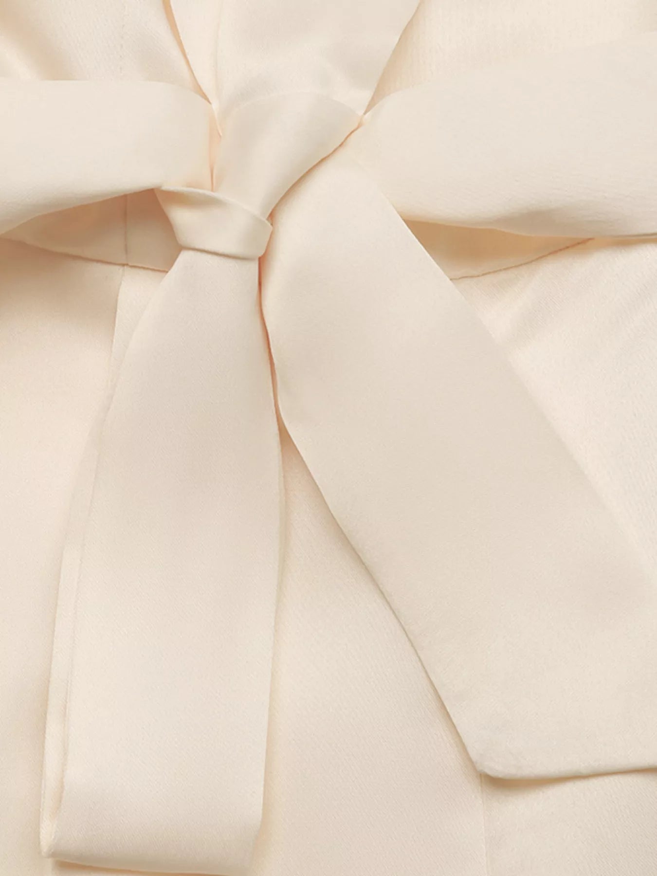 NEWYORKLISTED STYLE COLLECTION: Close-up of a cream-colored fabric with a bow detail
