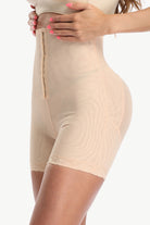 Beige shapewear being worn on a white background
