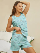 NEWYORKLISTED Intimate Apparel: Woman wearing a light blue pajama set with butterfly pattern on a beige background