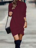 NEWYORKLISTED Style Collection: Person wearing a burgundy sweater dress with black knee-high boots and a black handbag.