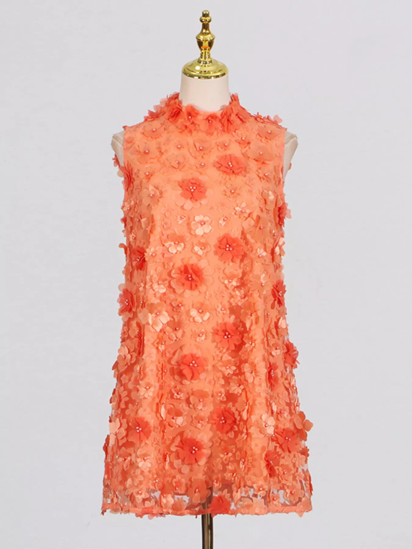 NEWYORKLISTED STYLE COLLECTION: Coral floral dress on a mannequin against a light gray background