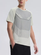 NEWYORKLISTED ATLAS MEN'S COLLECTION: Person wearing a modern, light-colored t-shirt with geometric patterns on a plain background