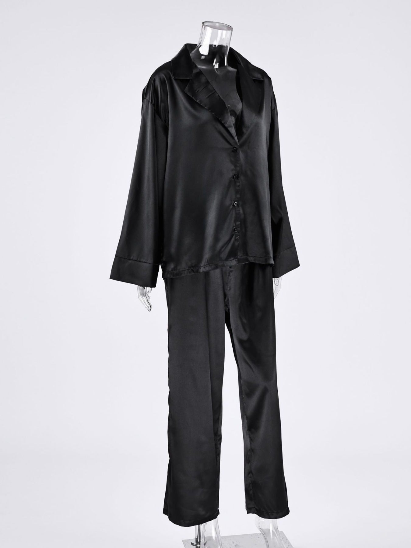 NEWYORKLISTED Intimate Apparel Collection: Black satin pajama set on a mannequin against a white background
