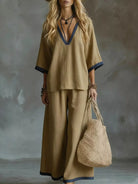 NEWYORKLISTED STYLE COLLECTION: Woman in a beige outfit holding a woven bag against a textured gray background