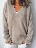 NEWYORKLISTED STYLE COLLECTION: Person wearing a beige sweater over a white shirt against a plain background