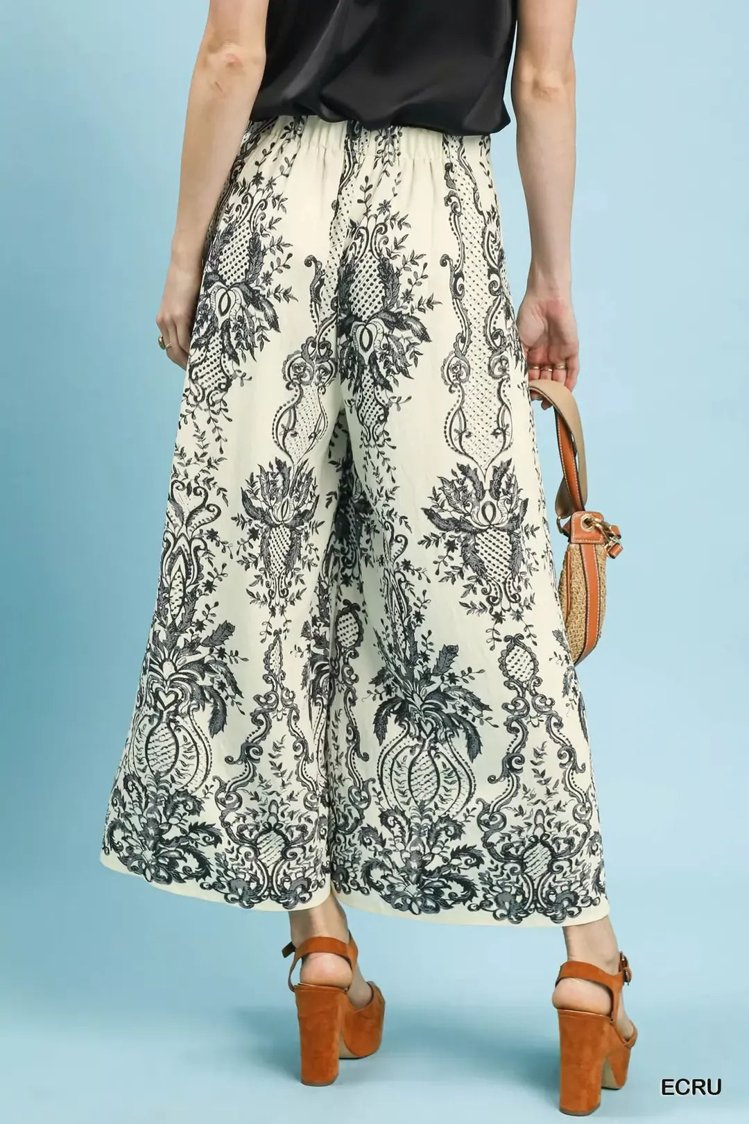 NEWYORKLISTED STYLE COLLECTION: Person wearing patterned pants with a plain background