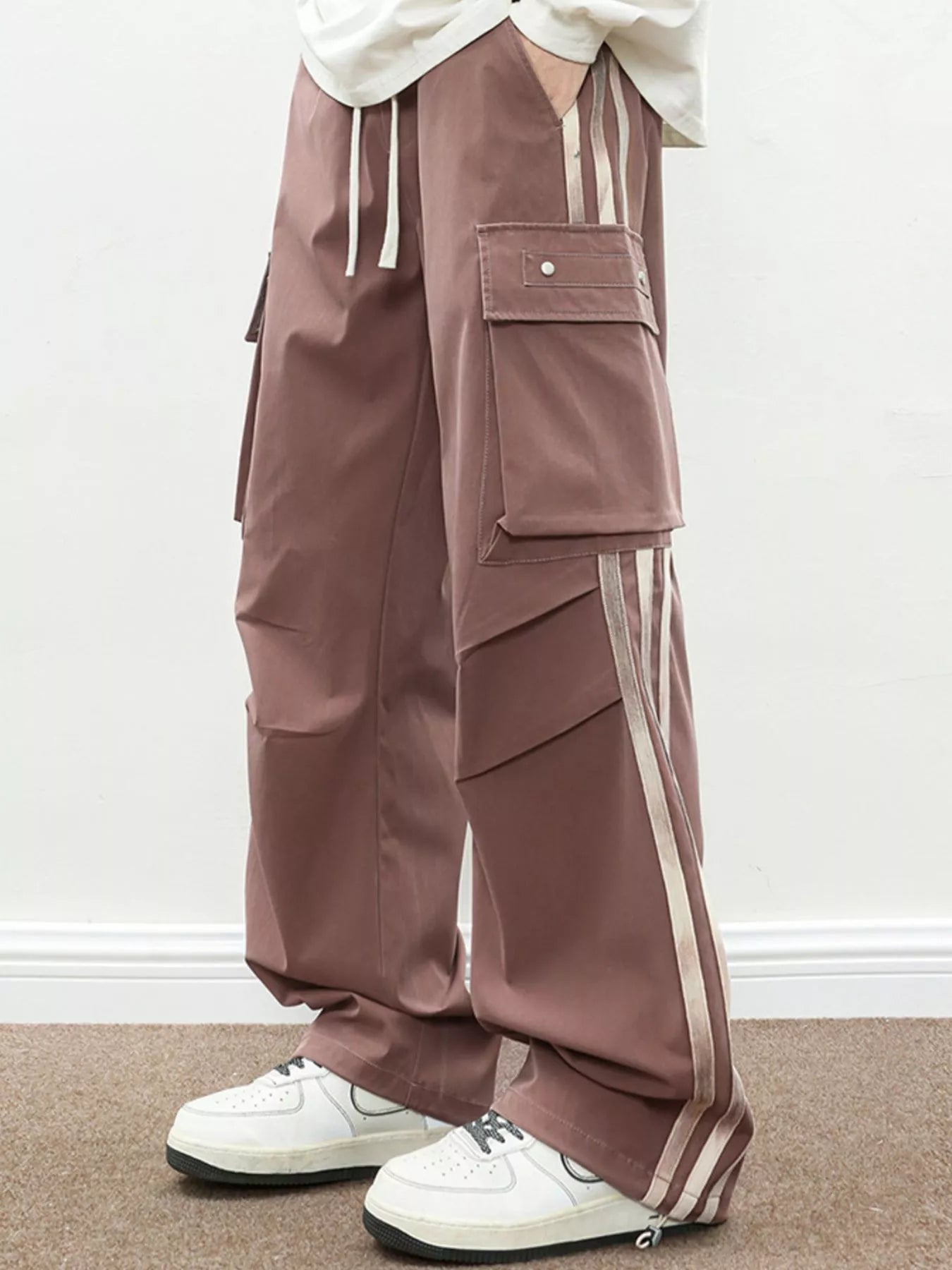 NEWYORKLISTED ATLAS MEN's COLLECTION: Brown cargo pants with white stripes worn by a person on a plain background