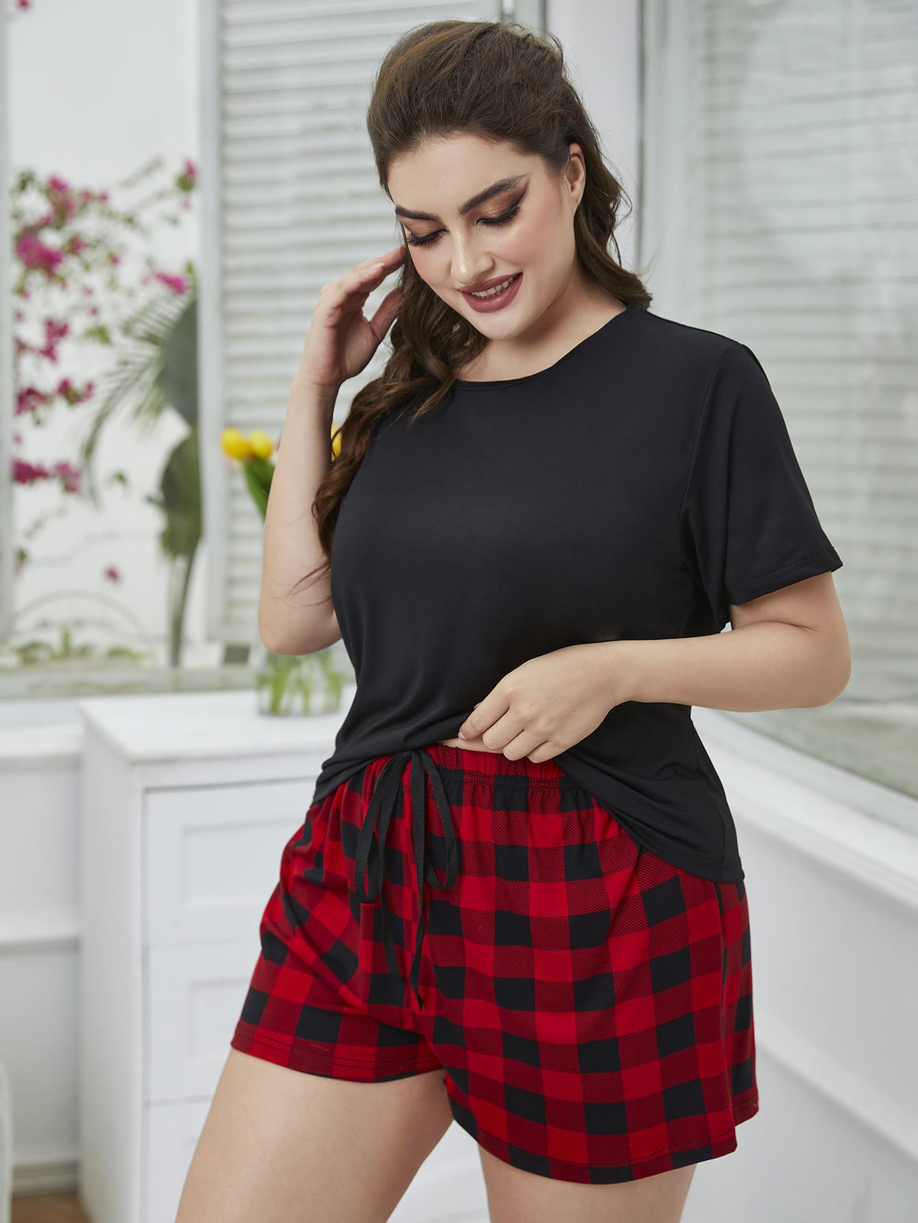 NEWYORKLISTED Intimate Apparel: Woman wearing a black t-shirt and red plaid shorts in a bright room.