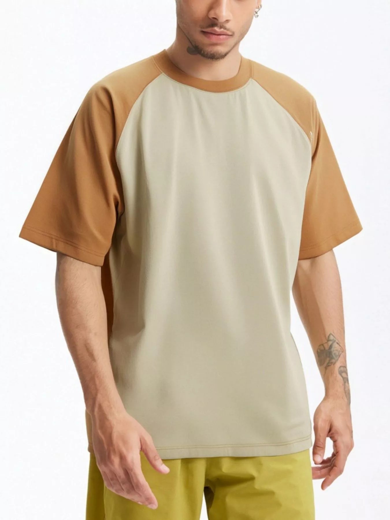 NEWYORKLISTED ATLAS MEN's COLLECTION: Man wearing a beige and brown baseball shirt with yellow pants on a white background