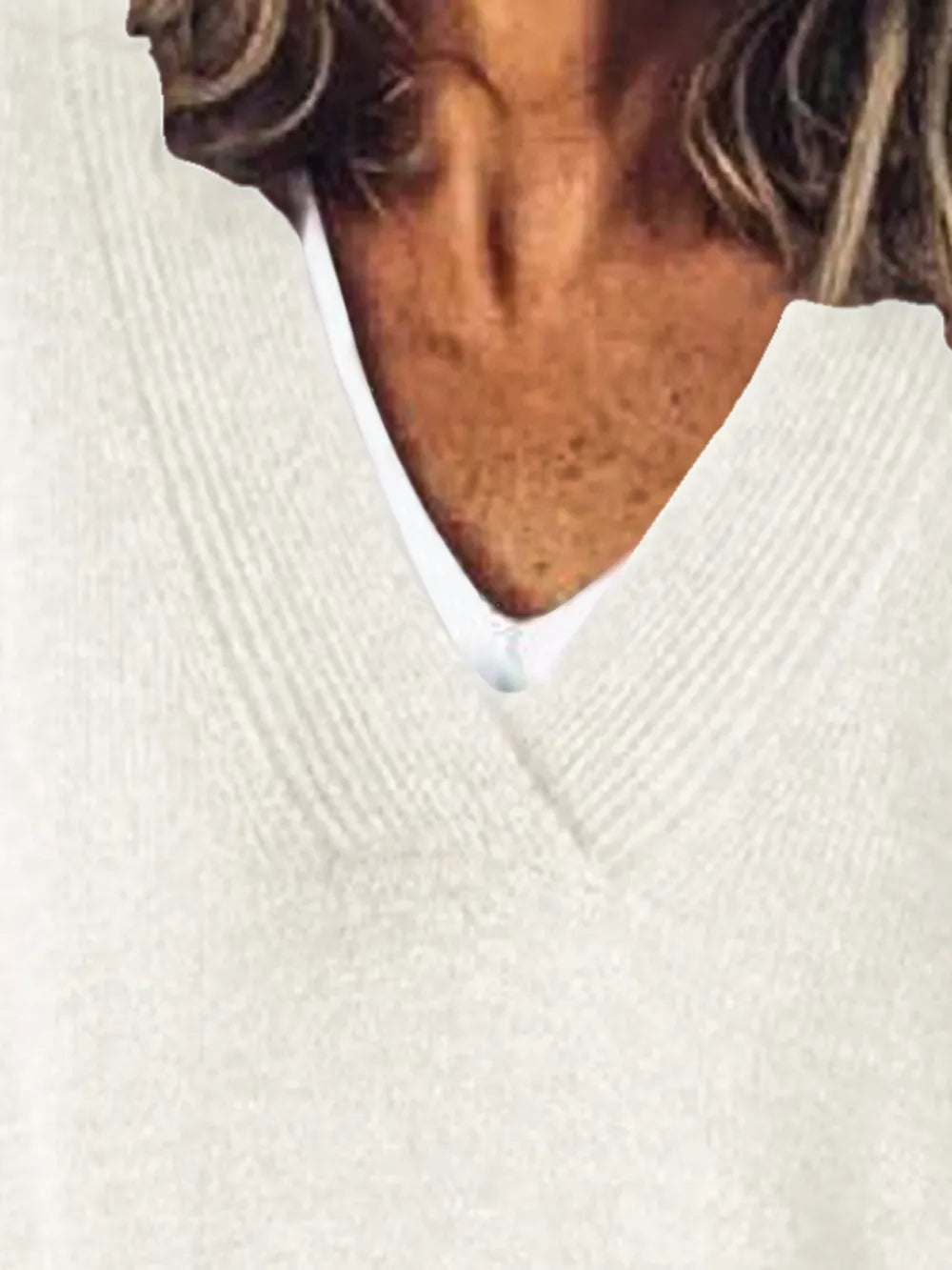 NEWYORKLISTED STYLE COLLECTION: Close-up of a person wearing a white sweater with a blurred background