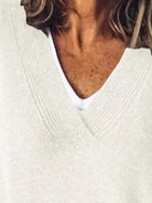 NEWYORKLISTED STYLE COLLECTION: Close-up of a person wearing a white sweater with a blurred background