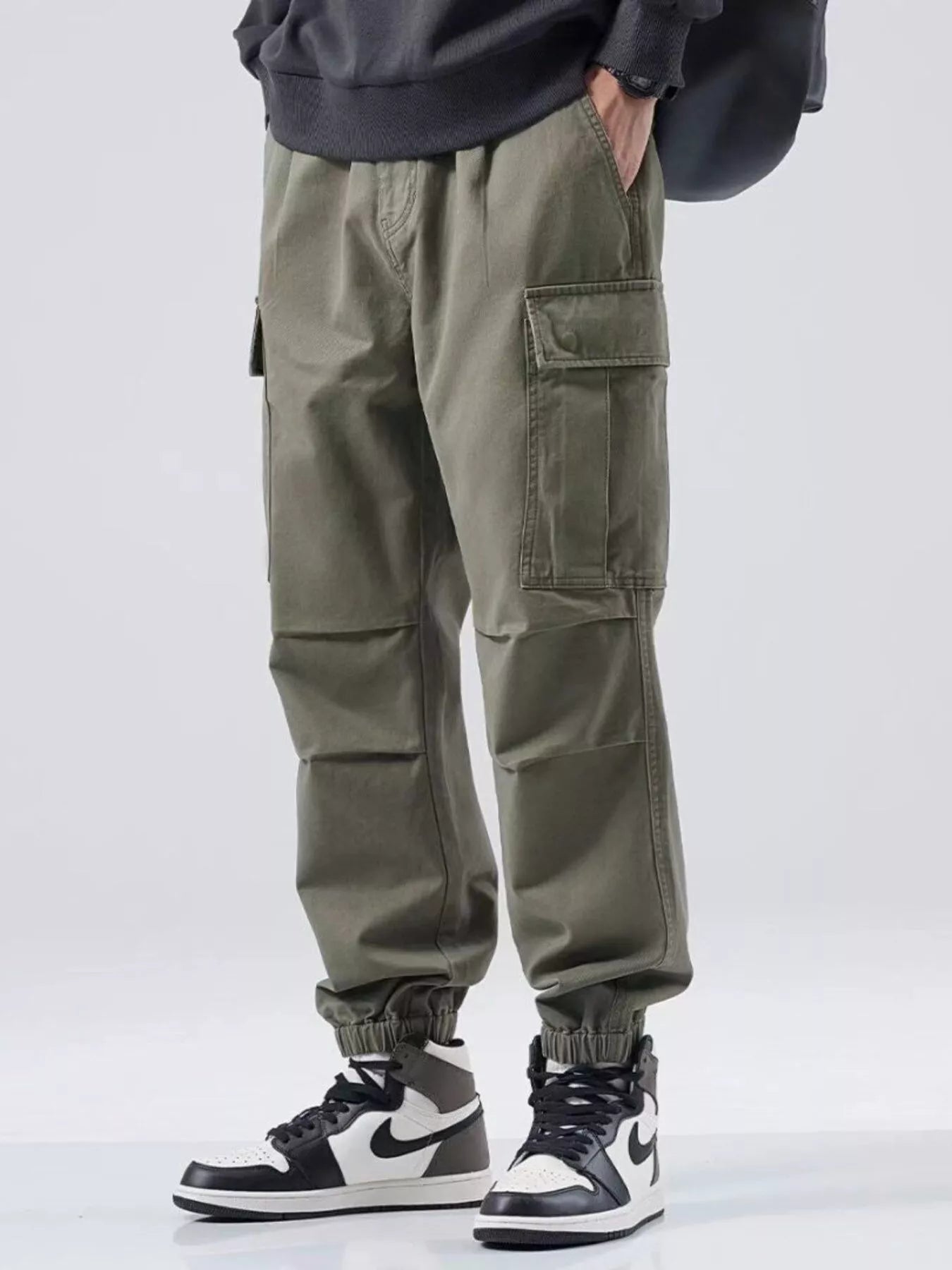 NEWYORKLISTED ATLAS MEN'S COLLECTION: Person wearing olive green cargo pants with a plain background