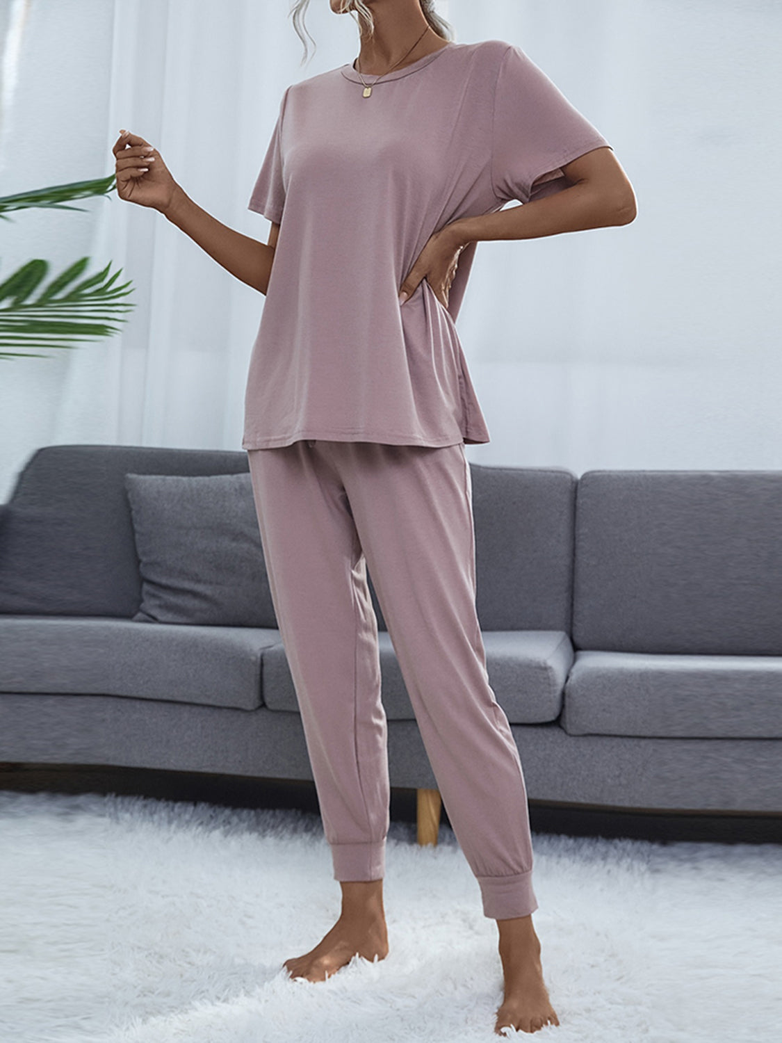 NEWYORKLISTED Intimate Apparel: Person wearing a pink pajama set in a living room setting.