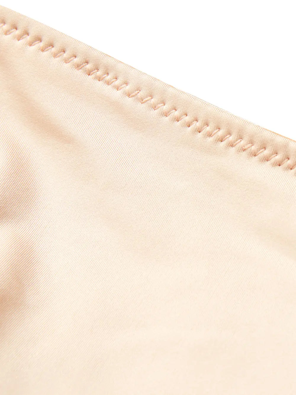 NEWYORKLISTED Intimate Apparel: Close-up of beige fabric with a focus on stitching detail