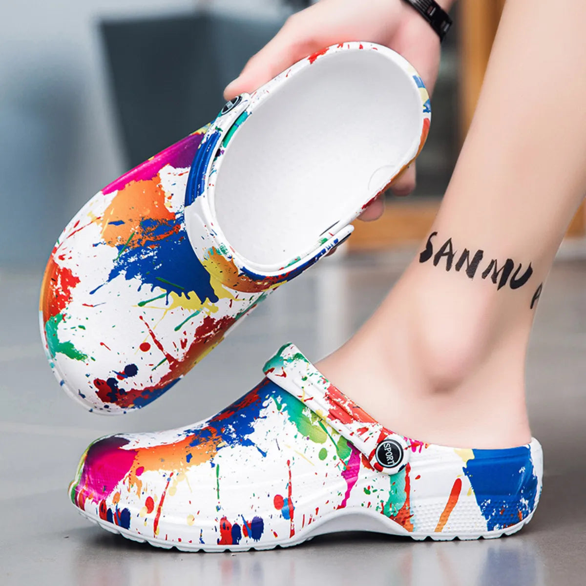 NEWYORKLISTED STYLE COLLECTION: Colorful splatter-patterned clogs being worn with a blurred background