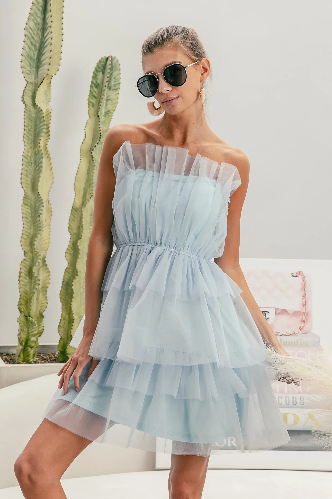 NEWYORKLISTED STYLE COLLECTION: Sleeveless Layered Organza Dress Woman wearing a light blue strapless dress with sunglasses indoors.