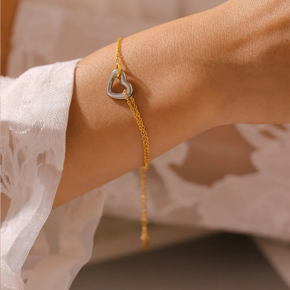 NEWYORKLISTED Valentine's Day Specials: Gold bracelet with a heart-shaped charm on a wrist against a neutral background