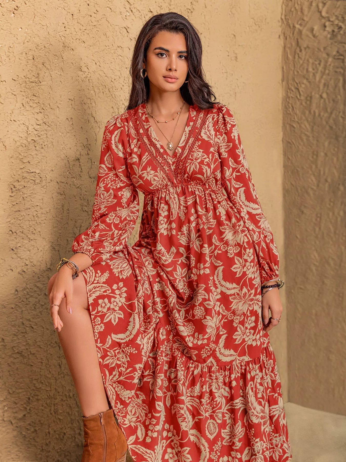 NEWYORKLISTED STYLE COLLECTION: Woman wearing a red floral dress against a beige wall
