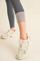 NEWYORKLISTED ACTIVEWEAR Person wearing light-colored sneakers and gray leggings on a neutral background showing the fleece lining on the leggings