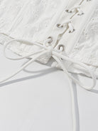 NEWYORKLISTED STYLE COLLECTION: Close-up of a white lace garment with laces on a light gray background