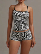 NEWYORKLISTED INTIMATE APPAREL COLLECTION: Woman wearing a zebra print swimsuit against a neutral background